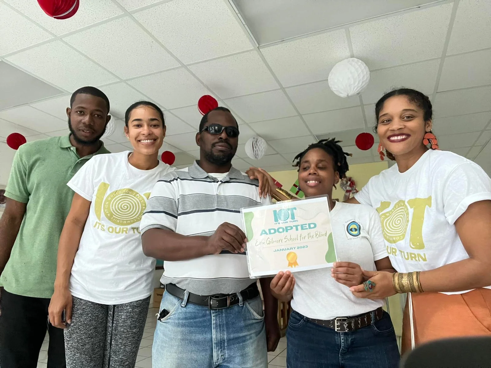 Children and IOT team members with an adoption certificate.