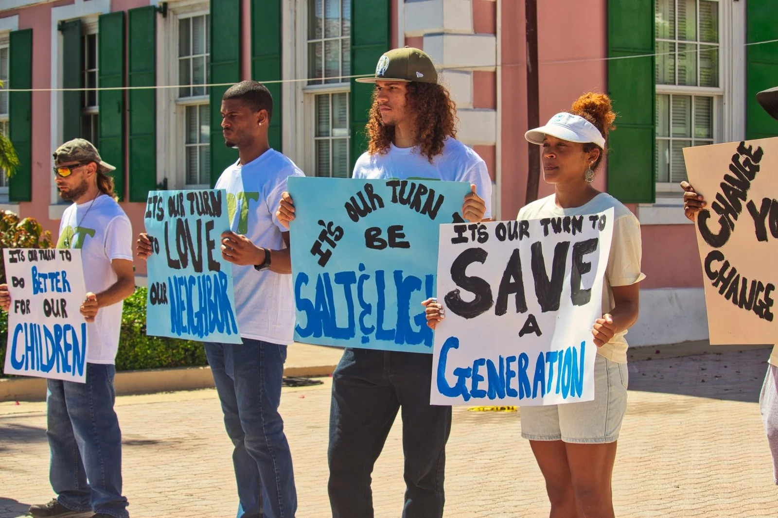 Young people standing together with It’s Our Turn shirts and signs.